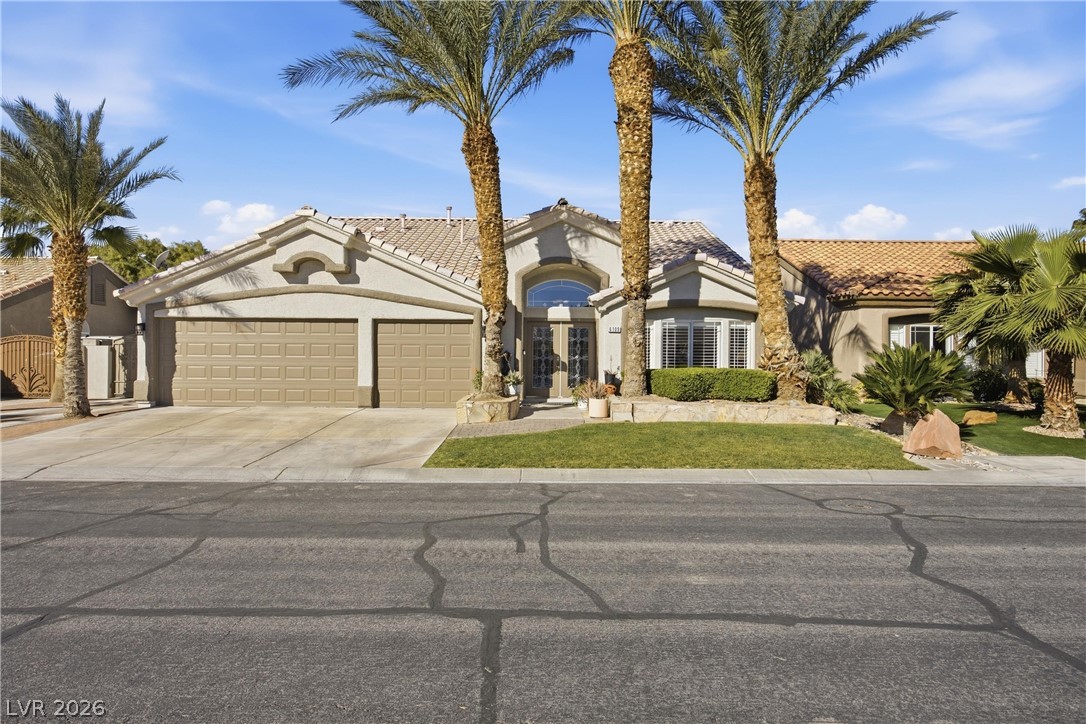 6109 Ocho Rios Street Las Vegas, NV 89130 - Photo 2 of 36 Mediterranean / spanish-style home featuring a tiled roof, a garage, stucco siding, concrete driveway, and a front yard