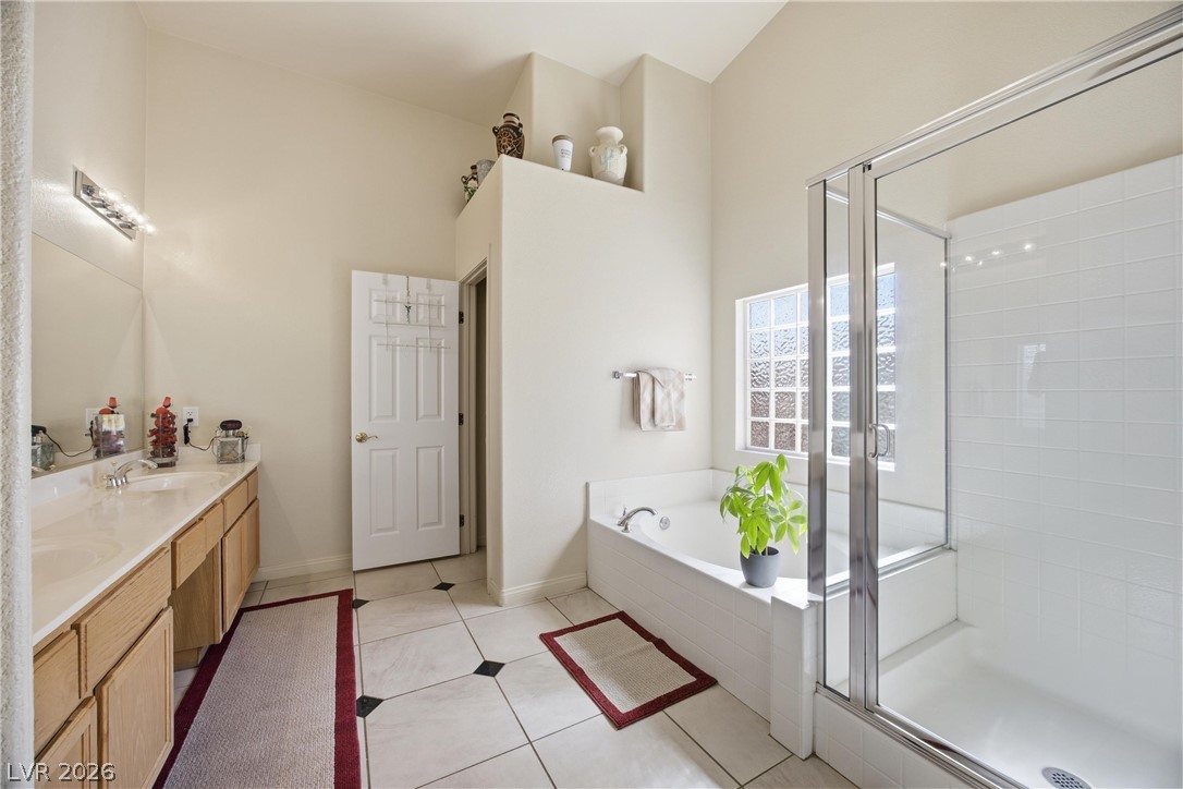 6109 Ocho Rios Street Las Vegas, NV 89130 - Photo 21 of 36 Full bath featuring a garden tub, a shower stall, double vanity, and light tile patterned flooring