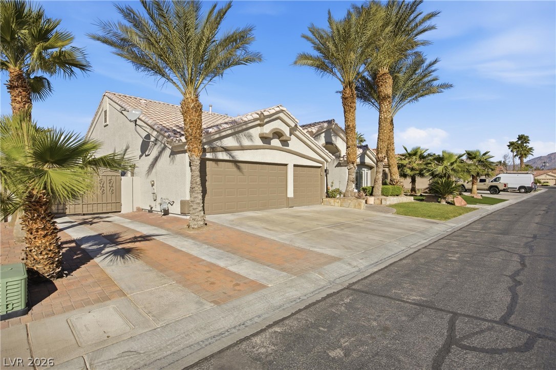 6109 Ocho Rios Street Las Vegas, NV 89130 - Photo 3 of 36 View of front of property featuring a garage, concrete driveway, stucco siding, and a tiled roof