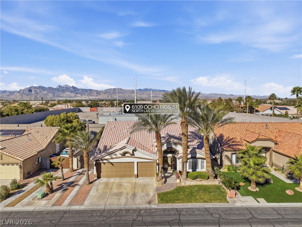 6109 Ocho Rios Street Las Vegas, NV 89130 - Photo 5 of 36 View of front of house with a garage, concrete driveway, a mountain view, and stucco siding