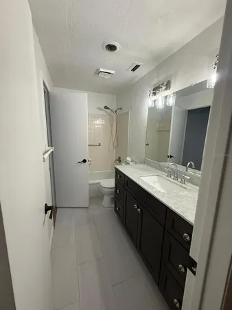 a bathroom with a double vanity sink mirror and toilet