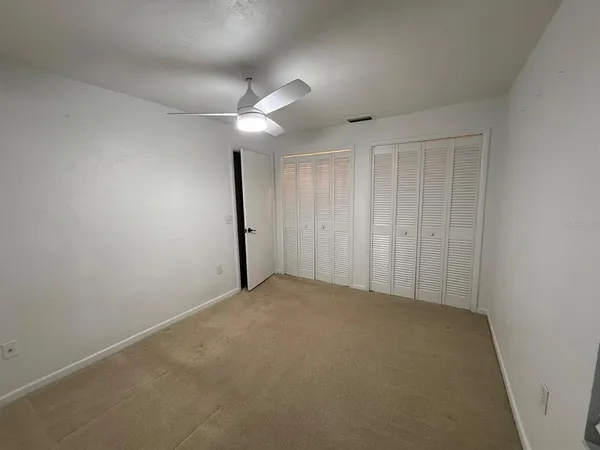 an empty room with a ceiling fan and fan
