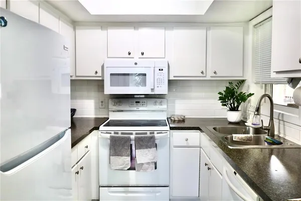 a kitchen with stainless steel appliances granite countertop a sink stove and cabinets