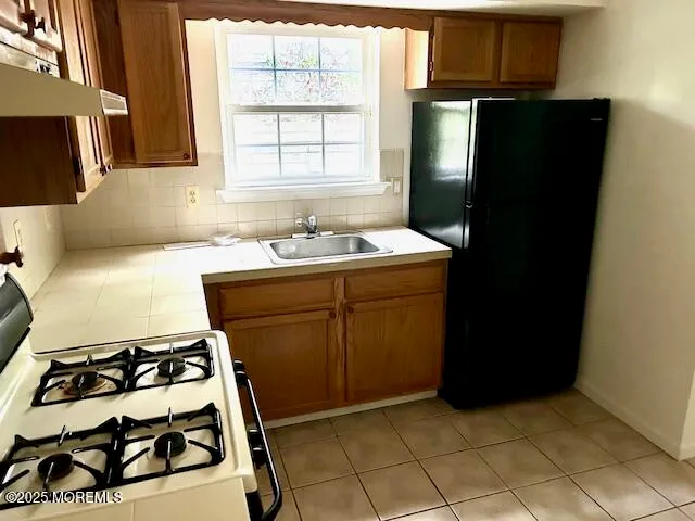 a kitchen with a sink stove and refrigerator