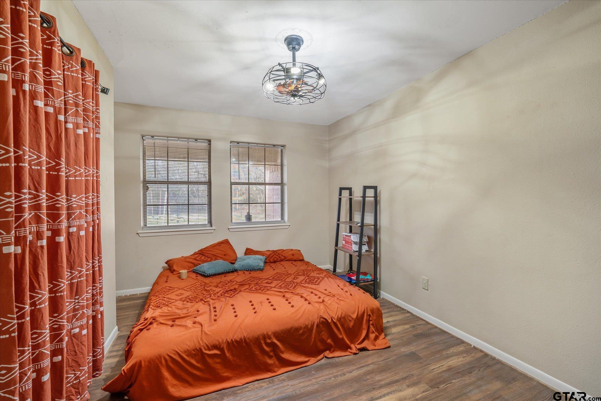 226 Colonial Circle Athens, TX 75751 - Photo 13 of 29 a bed sitting in a bedroom next to a window and a chandelier