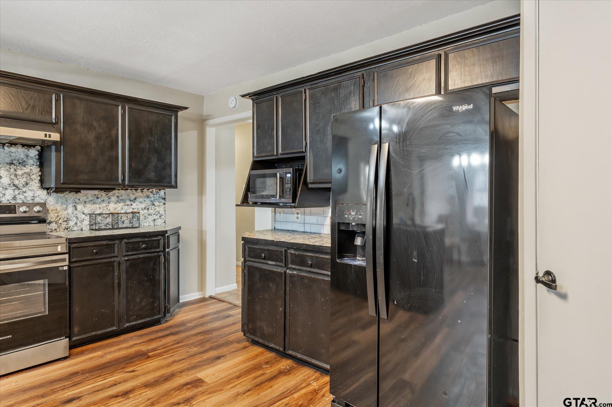 226 Colonial Circle Athens, TX 75751 - Photo 10 of 29 a kitchen with a refrigerator and a stove top oven