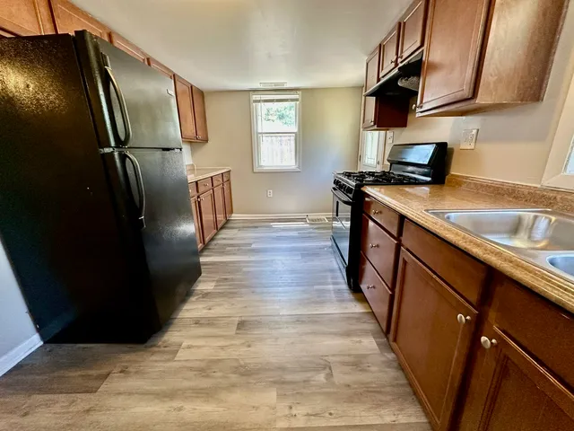 a kitchen with wooden cabinets and refrigerator