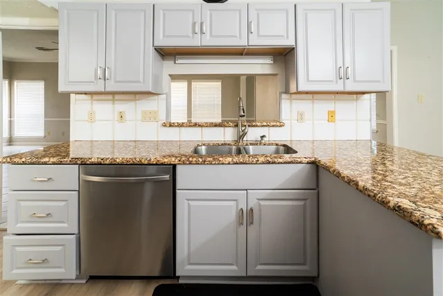 a kitchen with granite countertop a sink and a stove
