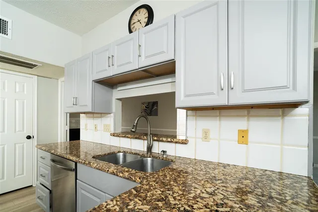 a kitchen with stainless steel appliances granite countertop a sink a stove and cabinets