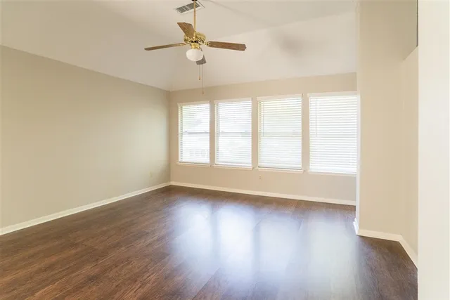 a view of a room with a window and wooden floor