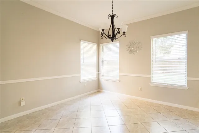 a view of empty room with a window and chandelier