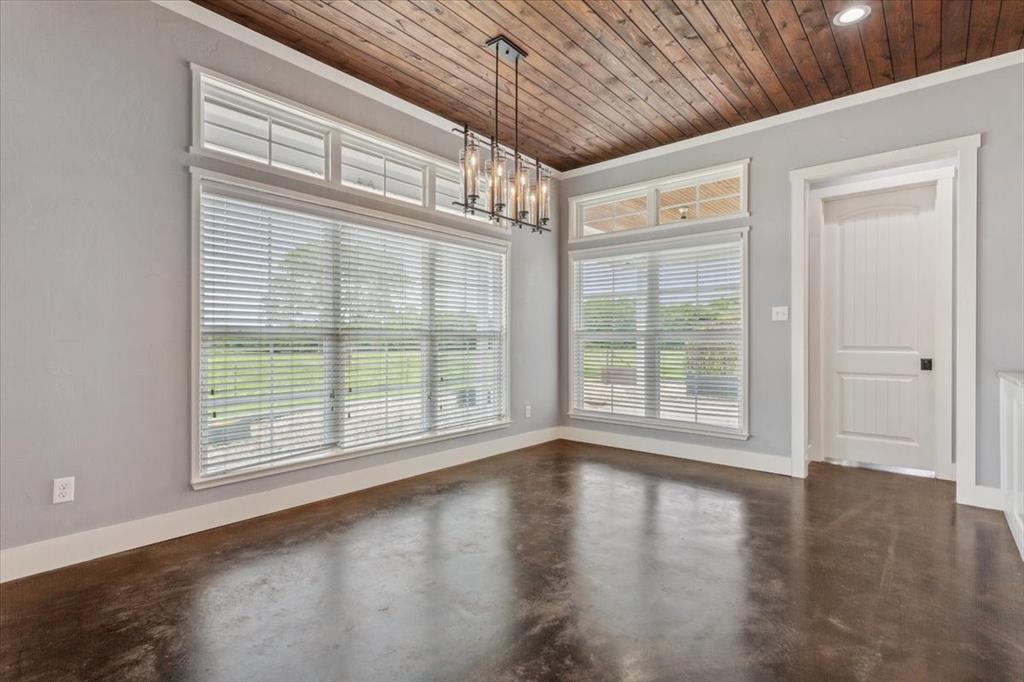 259 County Road 149 Riesel, TX 76682 - Photo 10 of 40 Unfurnished dining area featuring finished concrete floors, ornamental molding, a chandelier, baseboards, and wood ceiling
