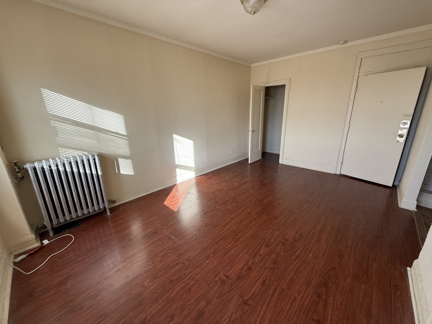 6930 North Greenview Avenue, Unit 608 Chicago, IL 60626 - Photo 4 of 10 a view of an empty room with wooden floor and a window
