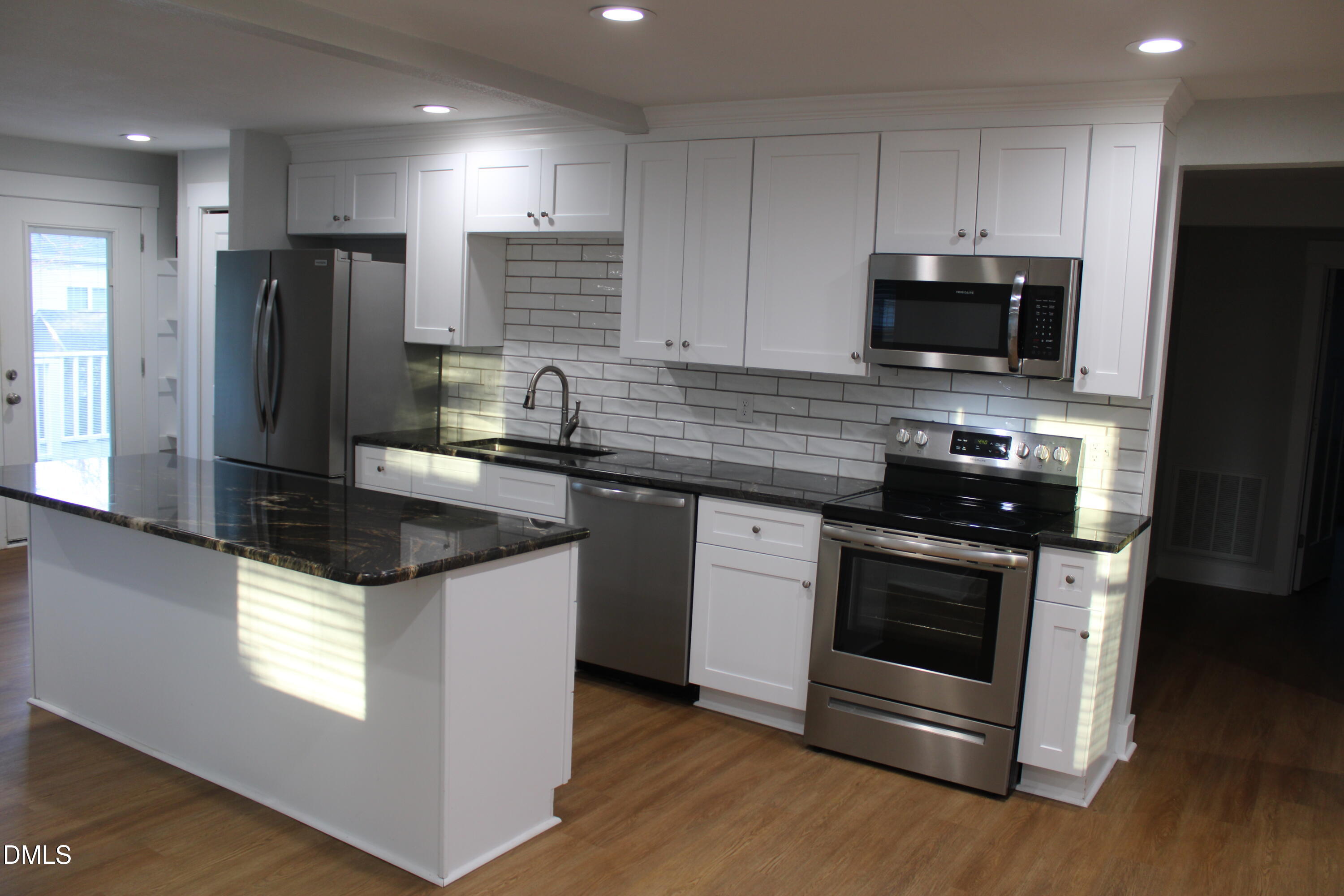 2812 Mayview Road Raleigh, NC 27607 - Photo 5 of 20 a kitchen with kitchen island granite countertop stainless steel appliances a sink a stove a microwave a refrigerator a counter top space and cabinets