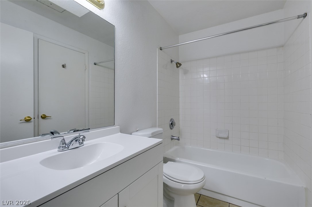 7570 West Flamingo Road, Unit 252 Las Vegas, NV 89147 - Photo 30 of 44 White tile surrounds the clean bathtub and shower, complemented by a simple vanity and mirror.