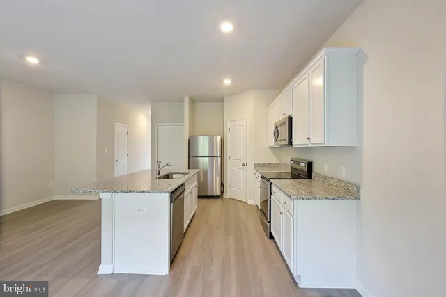 a kitchen with stainless steel appliances granite countertop a sink stove and cabinets