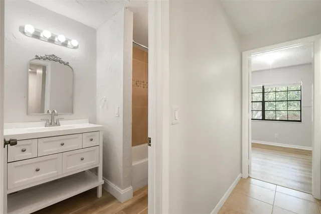 a bathroom with a sink mirror and a bathtub