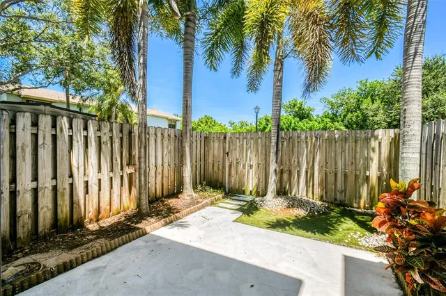 a view of a house with a small yard and wooden fence