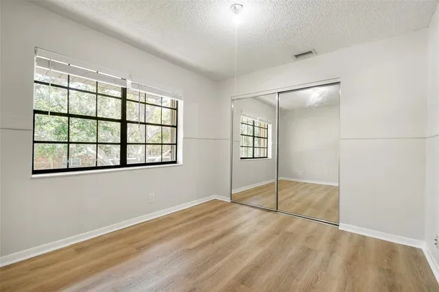 an empty room with windows and closet