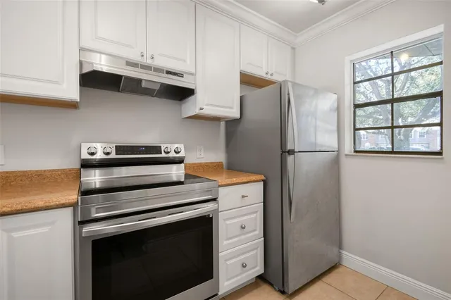 a kitchen with stainless steel appliances white cabinets and a refrigerator