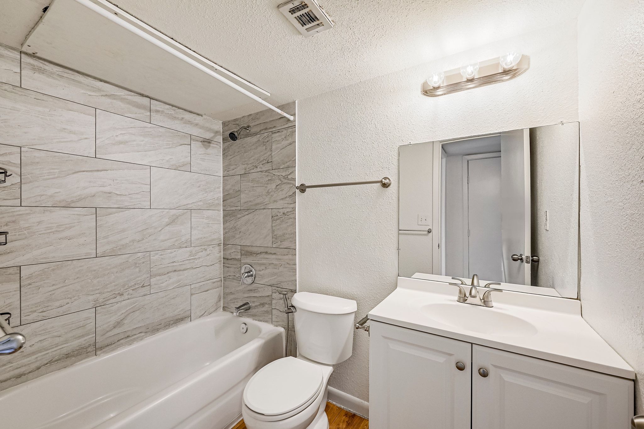 2207 Leon Street, Unit 201 Austin, TX 78705 - Photo 15 of 19 Bathroom featuring a textured wall, vanity, bathtub / shower combination, and a textured ceiling