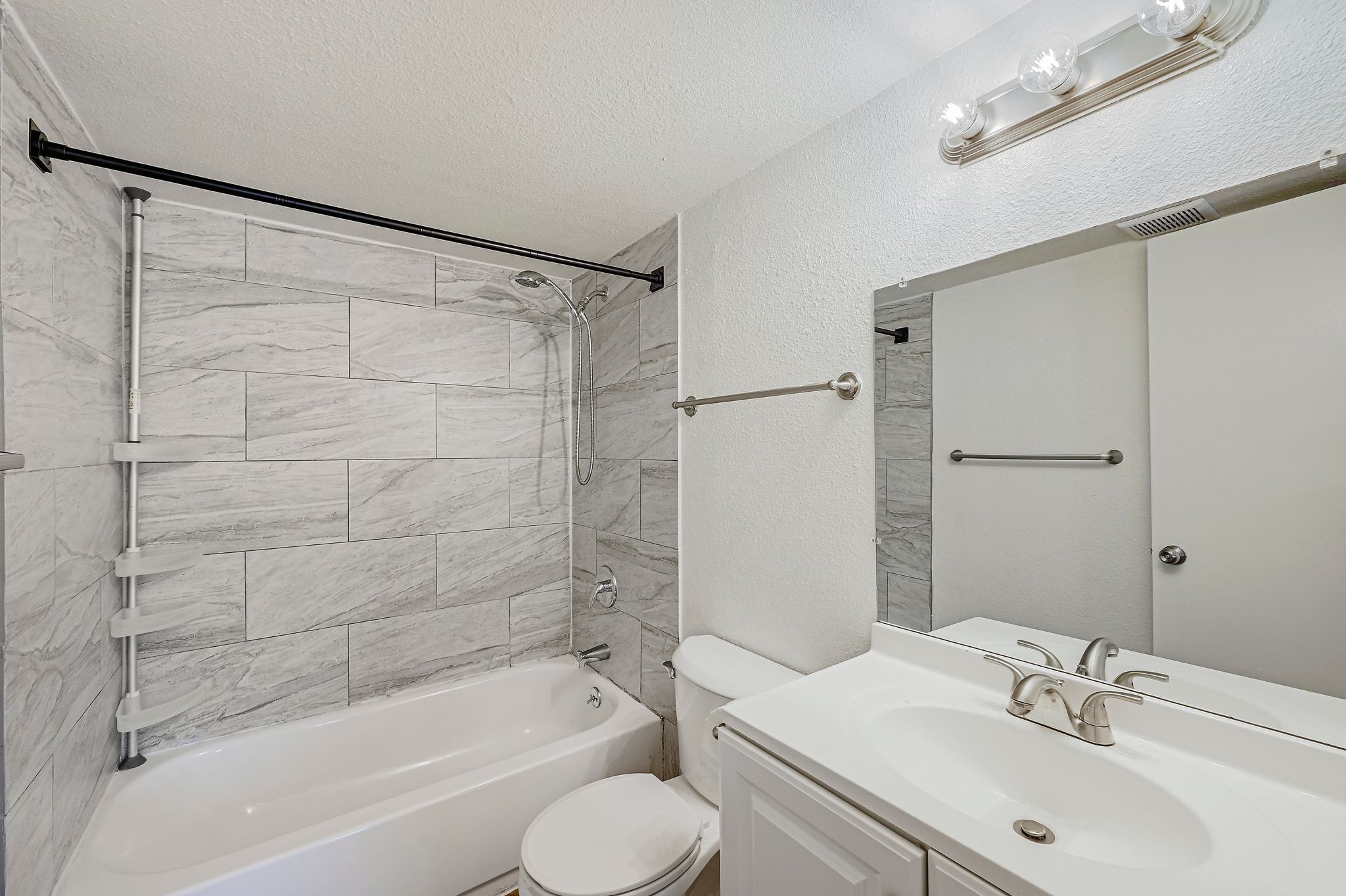 2207 Leon Street, Unit 201 Austin, TX 78705 - Photo 4 of 19 Bathroom with vanity, a textured ceiling, shower / tub combination, and a textured wall