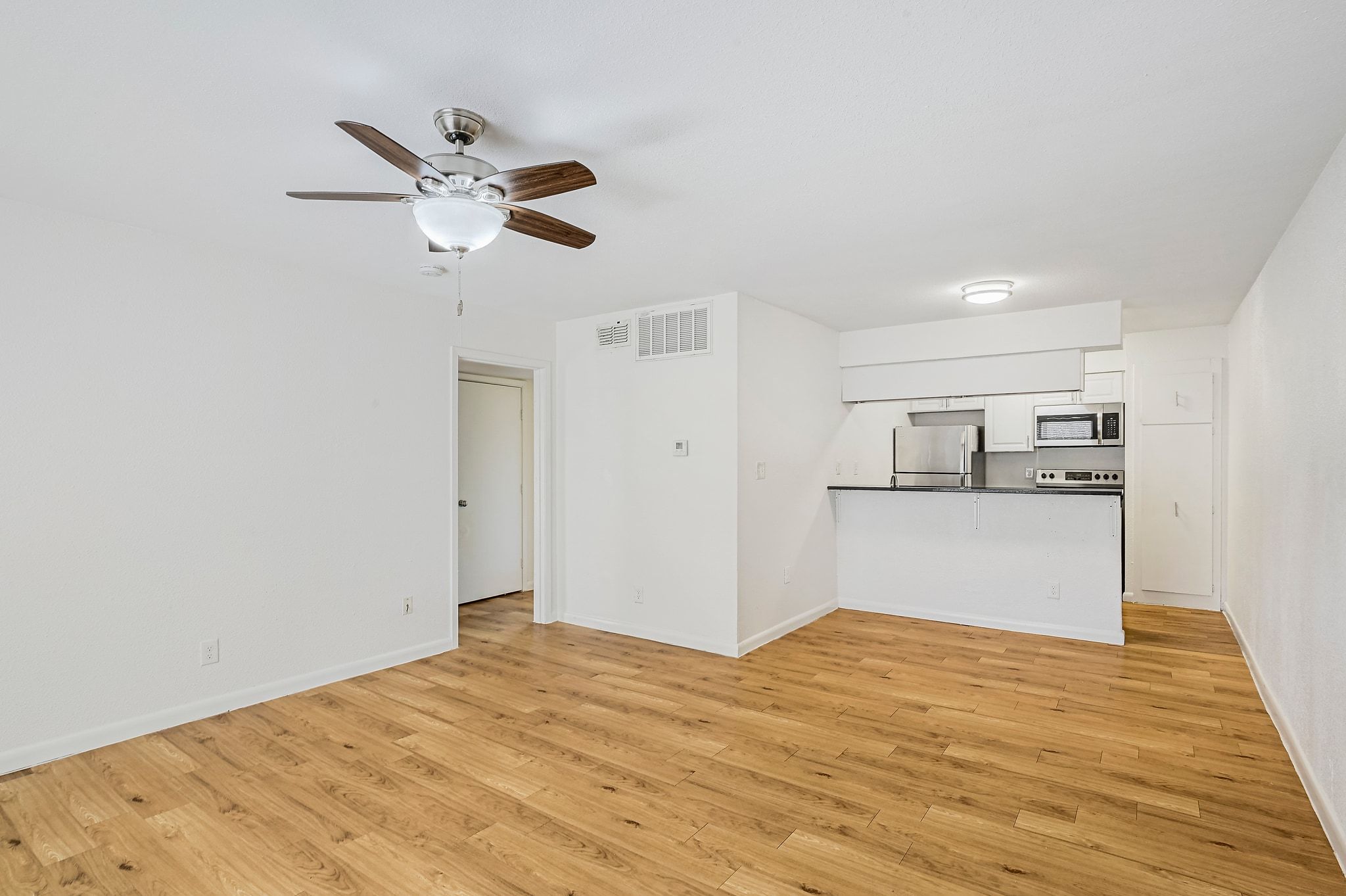 2207 Leon Street, Unit 201 Austin, TX 78705 - Photo 8 of 19 Unfurnished living room with light wood-style floors and a ceiling fan