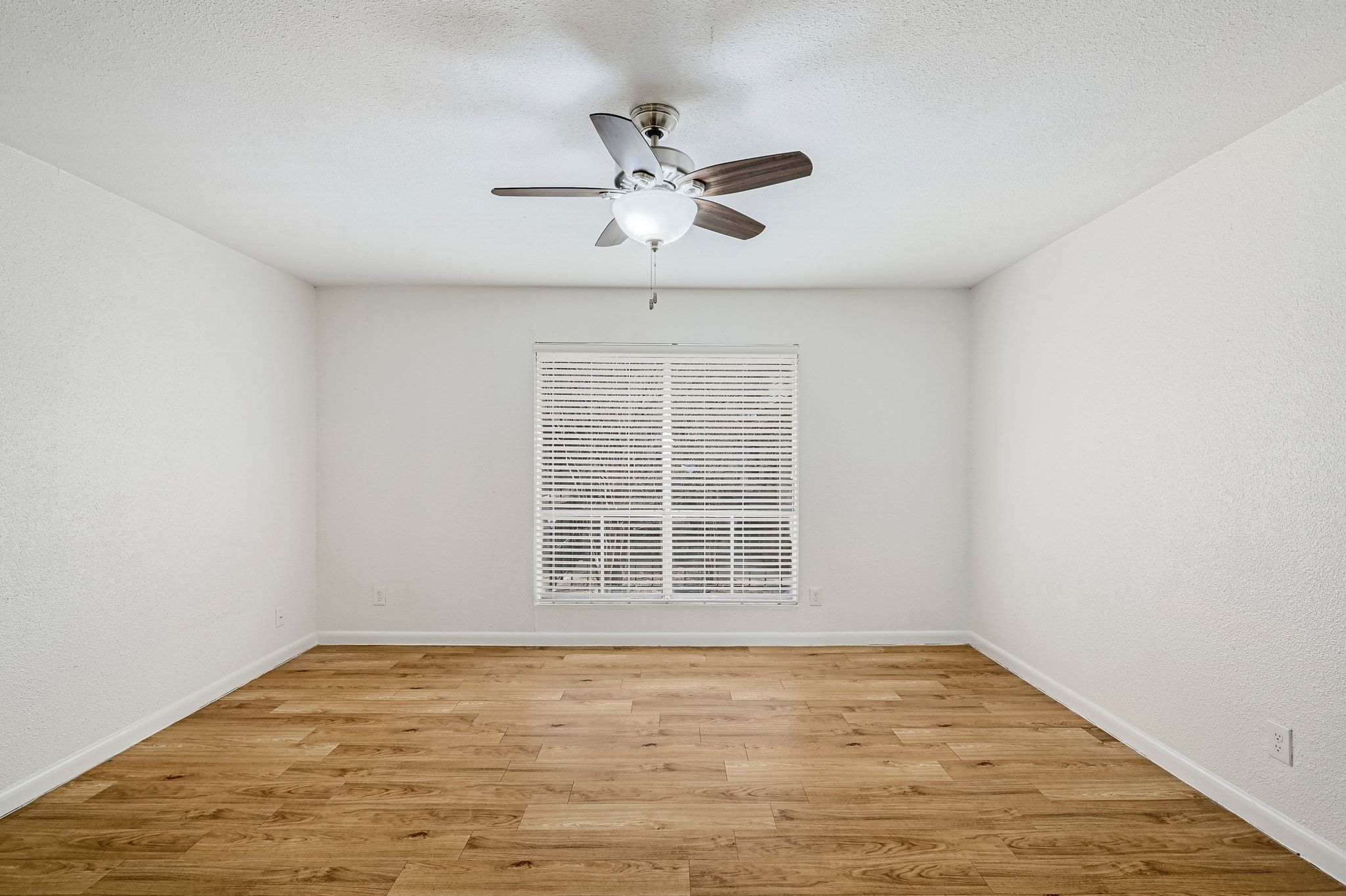 2207 Leon Street, Unit 201 Austin, TX 78705 - Photo 10 of 19 Spare room featuring light wood-type flooring, ceiling fan, a textured wall, and a textured ceiling