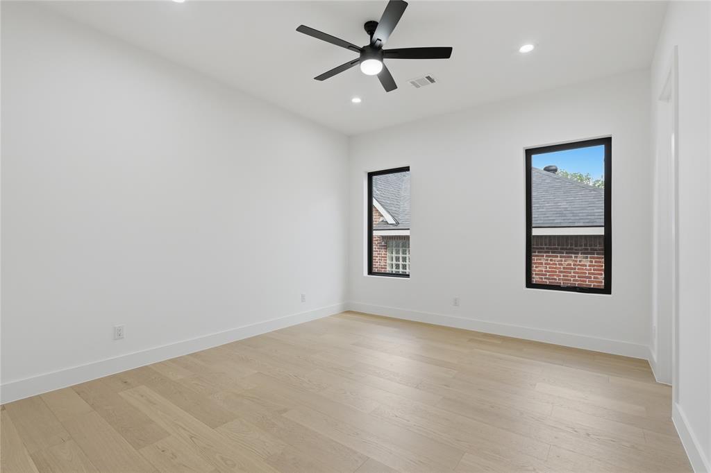 6038 Prospect Avenue Dallas, TX 75206 - Photo 34 of 40 Spacious room featuring white walls, light wood-finish flooring, and a ceiling fan with integrated lighting