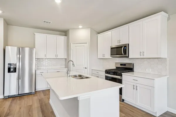 a kitchen with white cabinets and stainless steel appliances