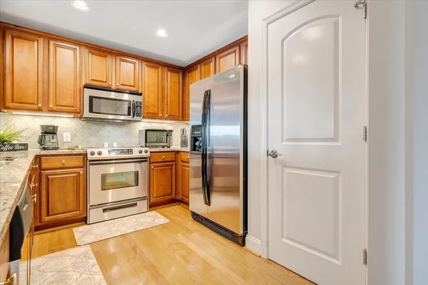 a kitchen with stainless steel appliances granite countertop a refrigerator stove and sink
