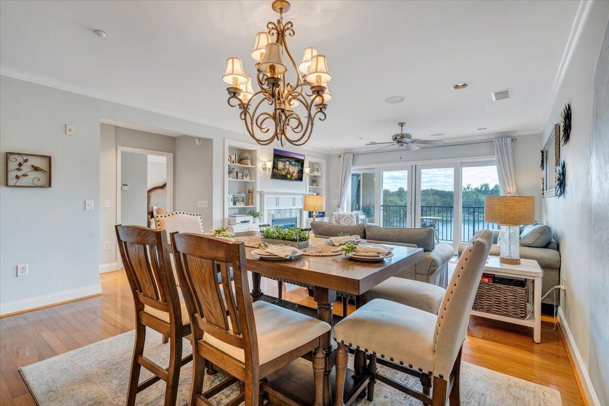 100 Bridgewater Pointe Place, Unit 502 Moneta, VA 24121 - Photo 25 of 54 a dining room with wooden floor a chandelier a wooden table and chairs
