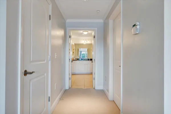 a view of a hallway with a livingroom and a bathroom with sink