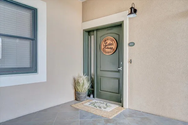 a view of a swimming pool and lounge chairs in back yard of the house