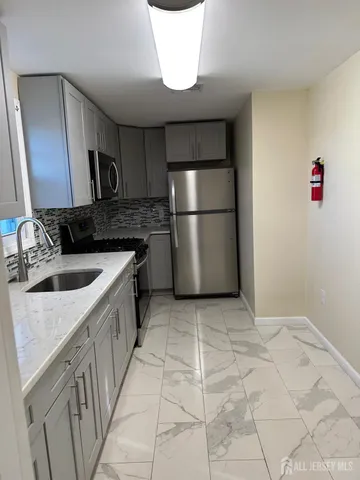 a kitchen with a sink a refrigerator and cabinets