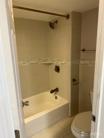 a bath room with a toilet and a bath tub