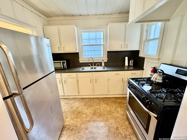 a kitchen with stainless steel appliances a refrigerator a sink a stove a microwave and cabinets