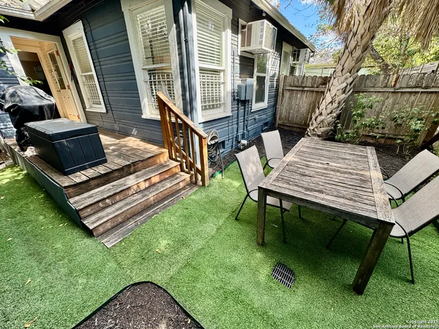 a view of a patio with table and chairs with wooden floor and fence