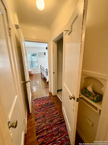 a view of a hallway with wooden floor and stairs