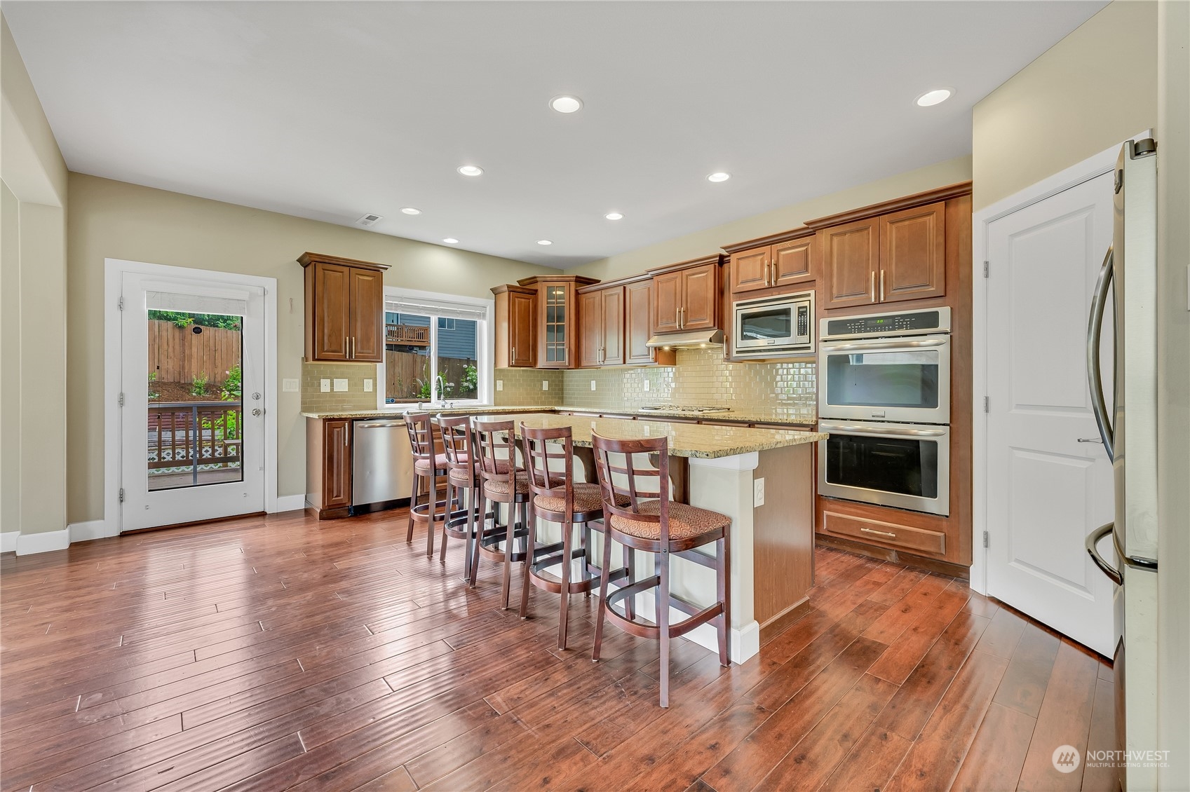 1118 Southwest 338th Street Federal Way, WA 98023 - Photo 9 of 25 an open kitchen with wooden floor and refrigerator