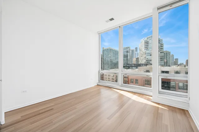 a view of a living room with a floor to ceiling window and wooden floor