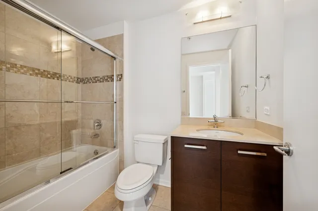 a bathroom with a granite countertop sink a toilet and shower