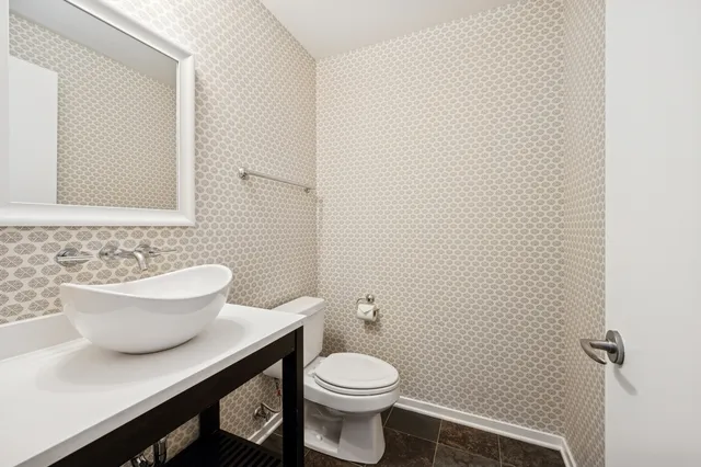 a white toilet sitting next to a bathroom sink