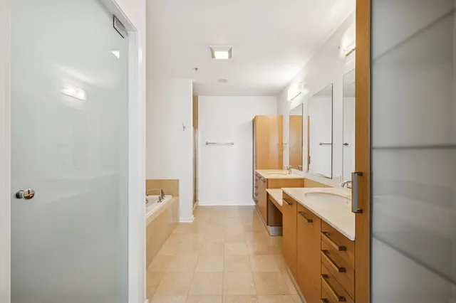 a bathroom with a double vanity sink a mirror and a bathtub