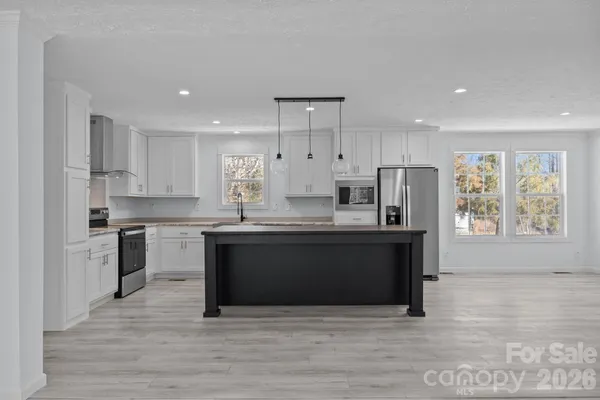 a large kitchen with stainless steel appliances granite countertop a stove a sink and a refrigerator