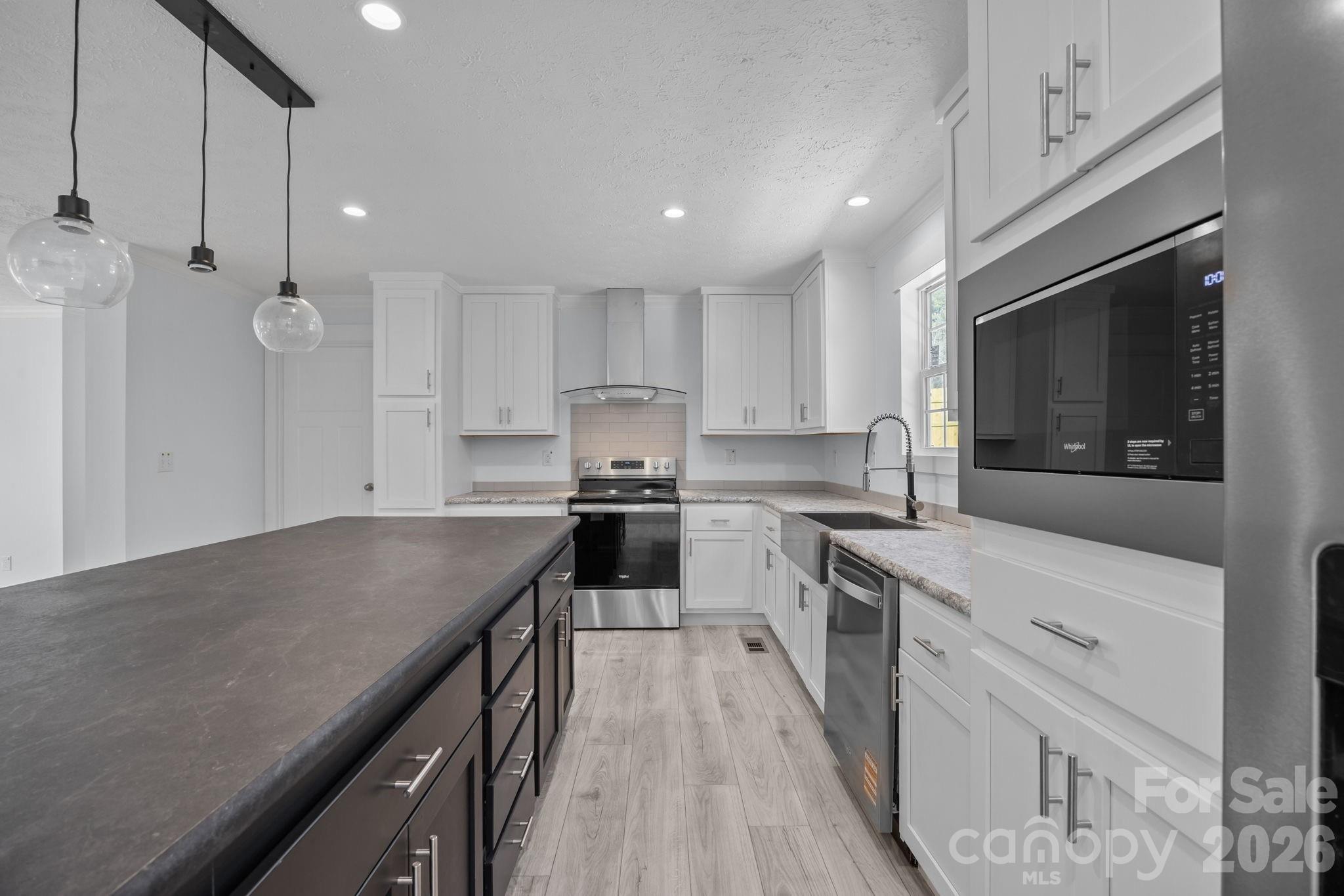 13190 Old Beatty Ford Road Rockwell, NC 28138 - Photo 8 of 23 a kitchen with granite countertop kitchen island white cabinets stainless steel appliances and sink