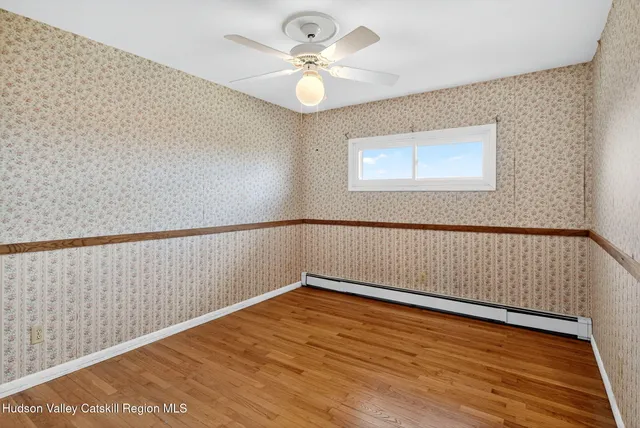 a view of an empty room with wooden floor