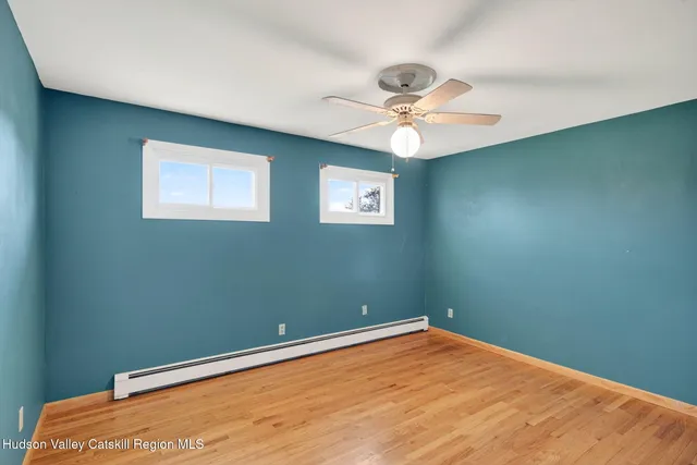 an empty room with a window and a fan
