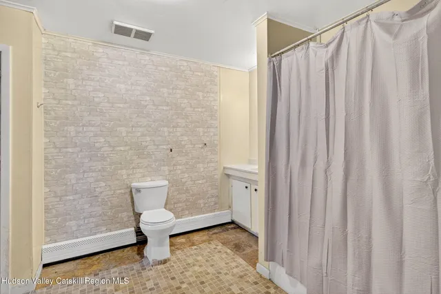 a bathroom with a toilet and a shower curtain