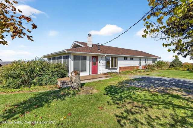 an aerial view of residential houses with outdoor space and trees